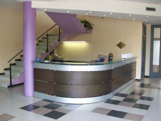 Un área de recepción con escaleras y piso cuadriculado.