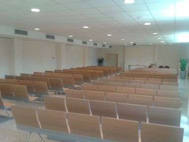 Filas de sillas de madera en una gran sala.