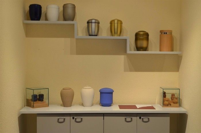 Una exhibición de urnas en estantes en una habitación.