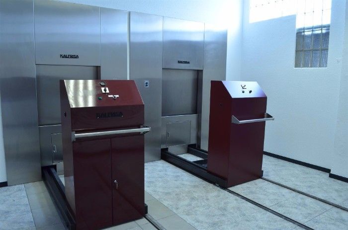 Una habitación con una puerta de acero inoxidable y un armario rojo.