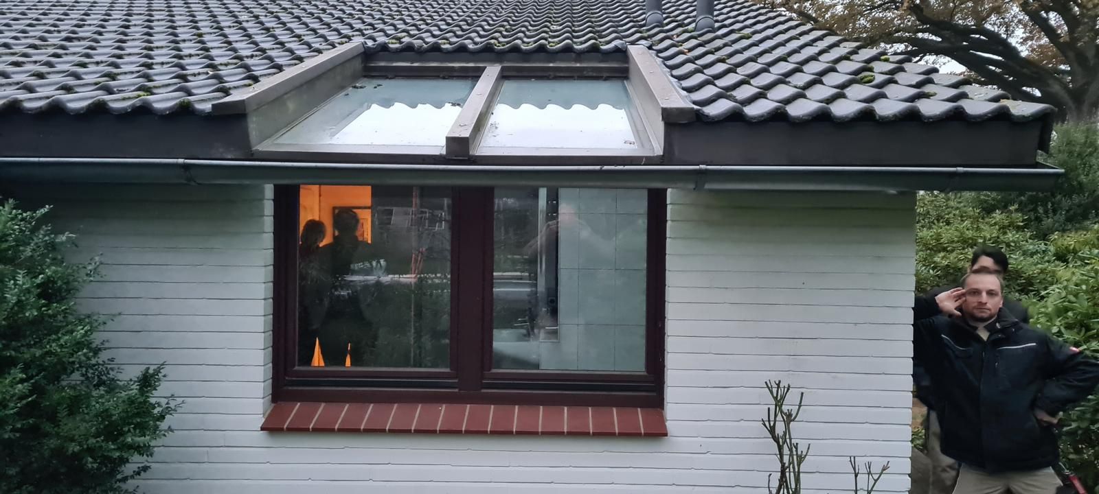 Ein Mann steht vor einem weißen Haus mit einem Fenster. Ein Mann steht vor einem weißen Haus mit einem Fenster.