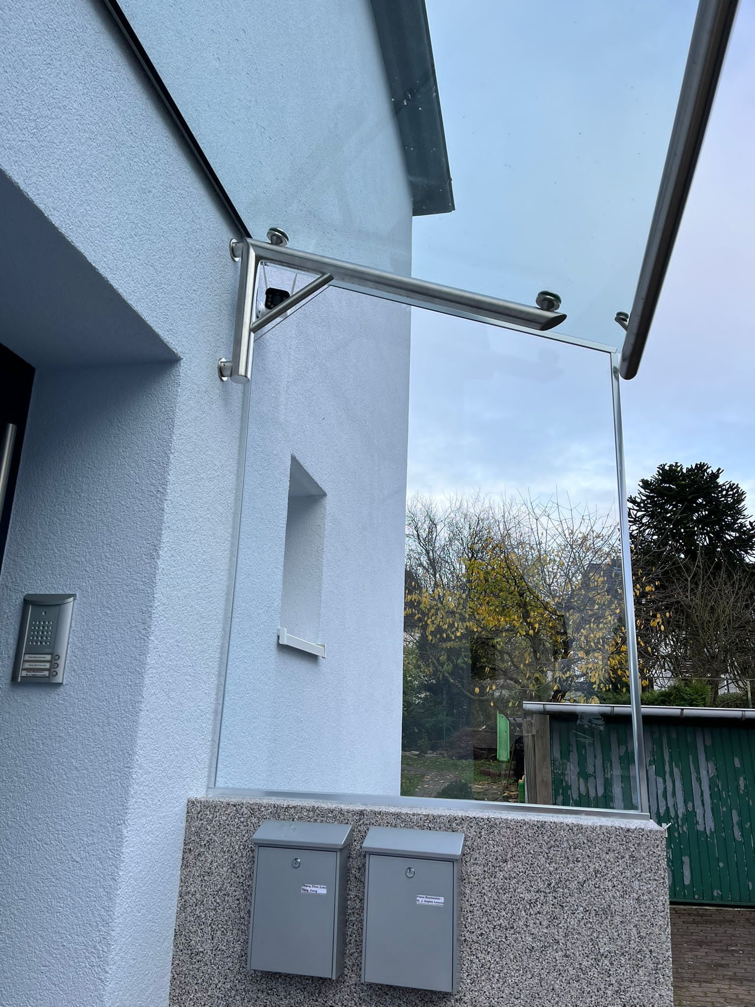 Glasdach an einem weißen Haus.