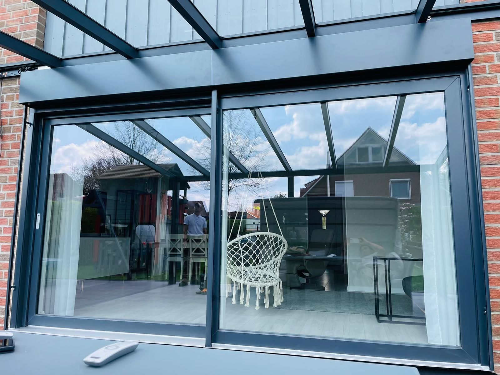 Ein großes Fenster mit einer Glasschiebetür, die zu einem Wohnzimmer führt.