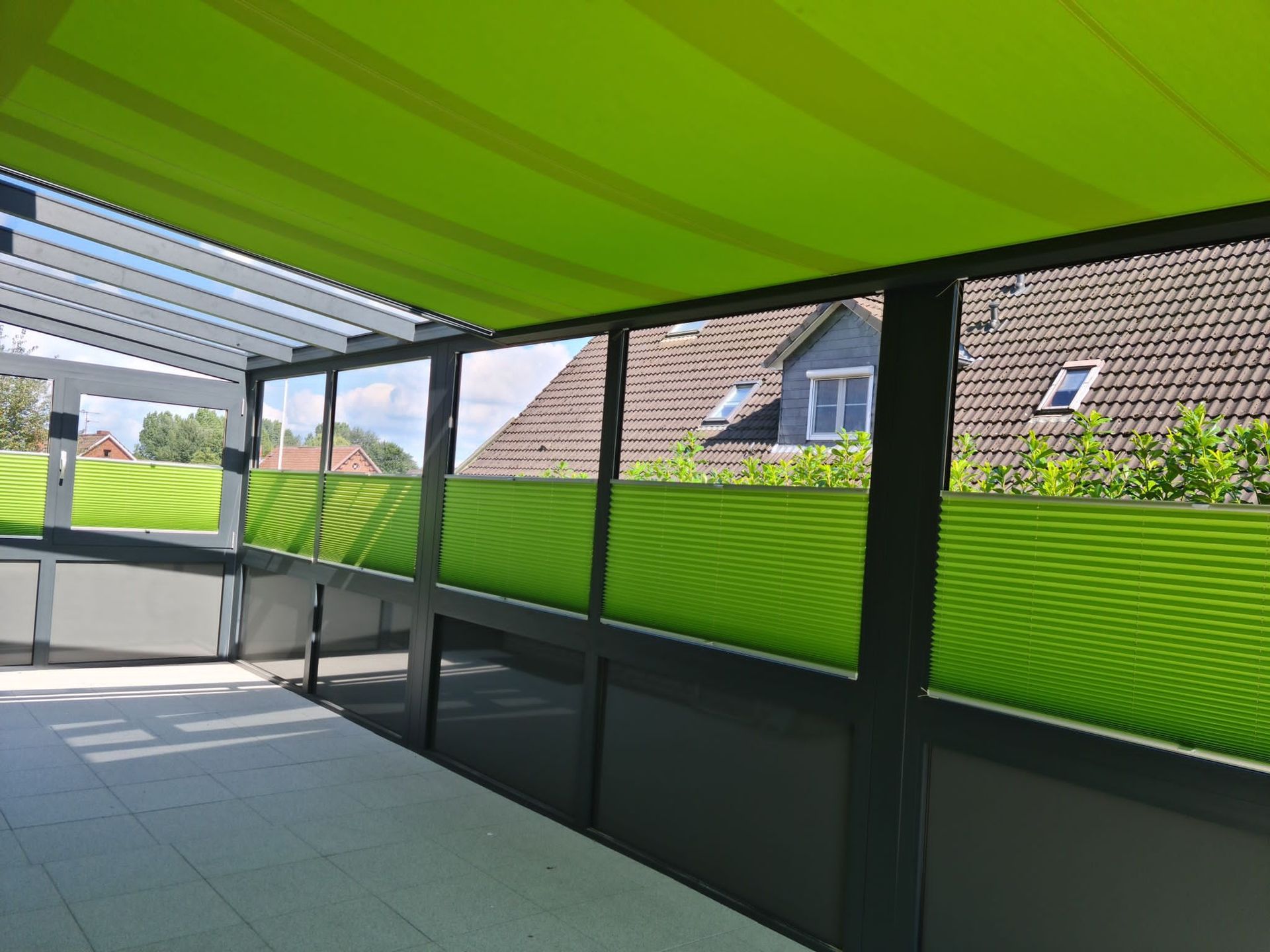 Ein Balkon mit grünen Jalousien und einer grünen Markise.