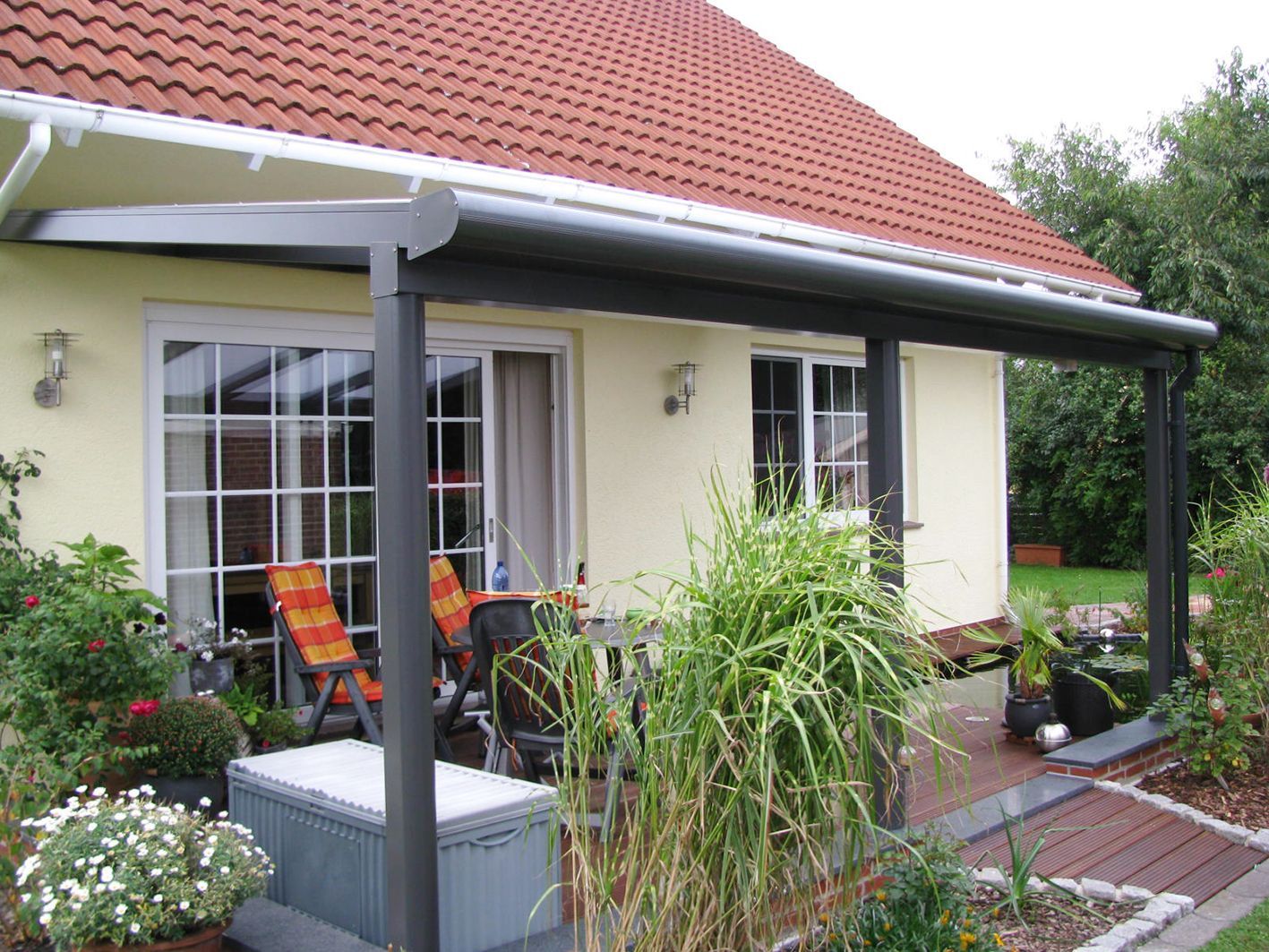 Ein Haus mit einer überdachten Veranda mit Stühlen und einem Tisch