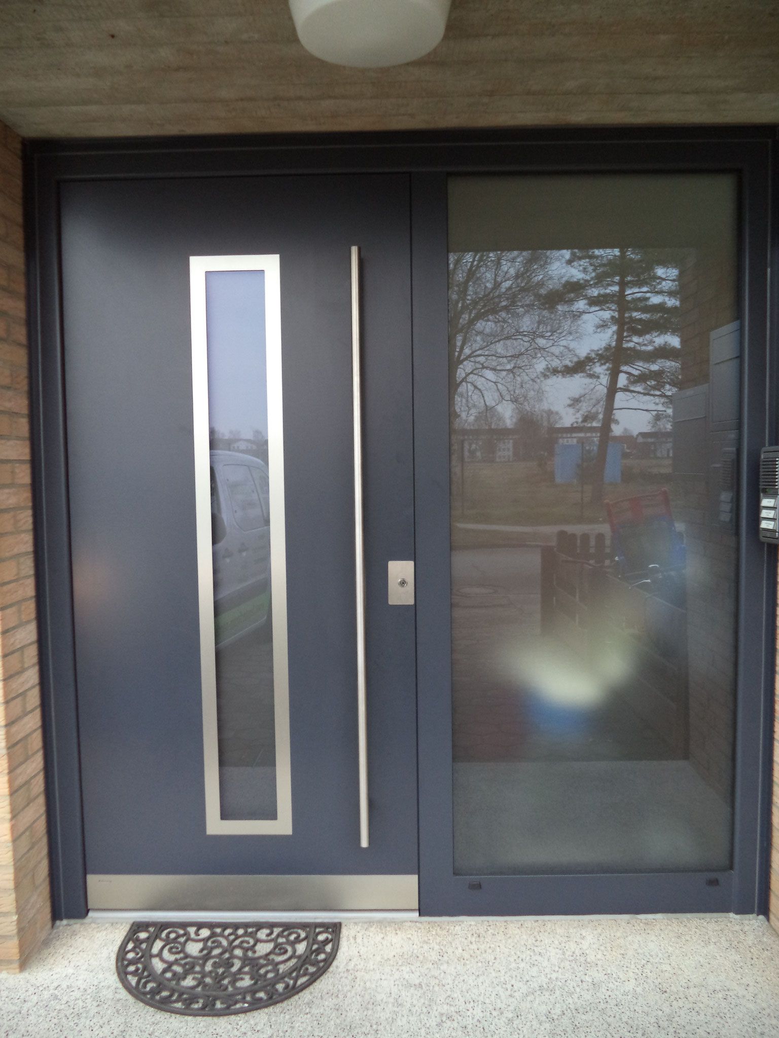 Eine schwarze Tür mit einem Edelstahlgriff