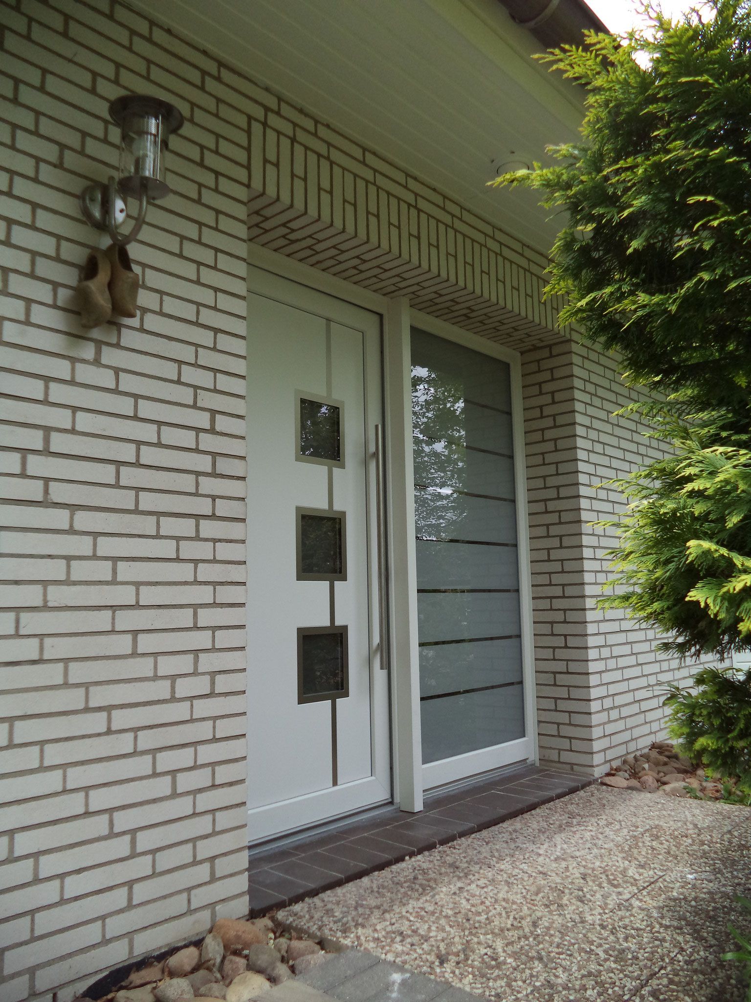 Ein weißes Backsteingebäude mit einer weißen Tür