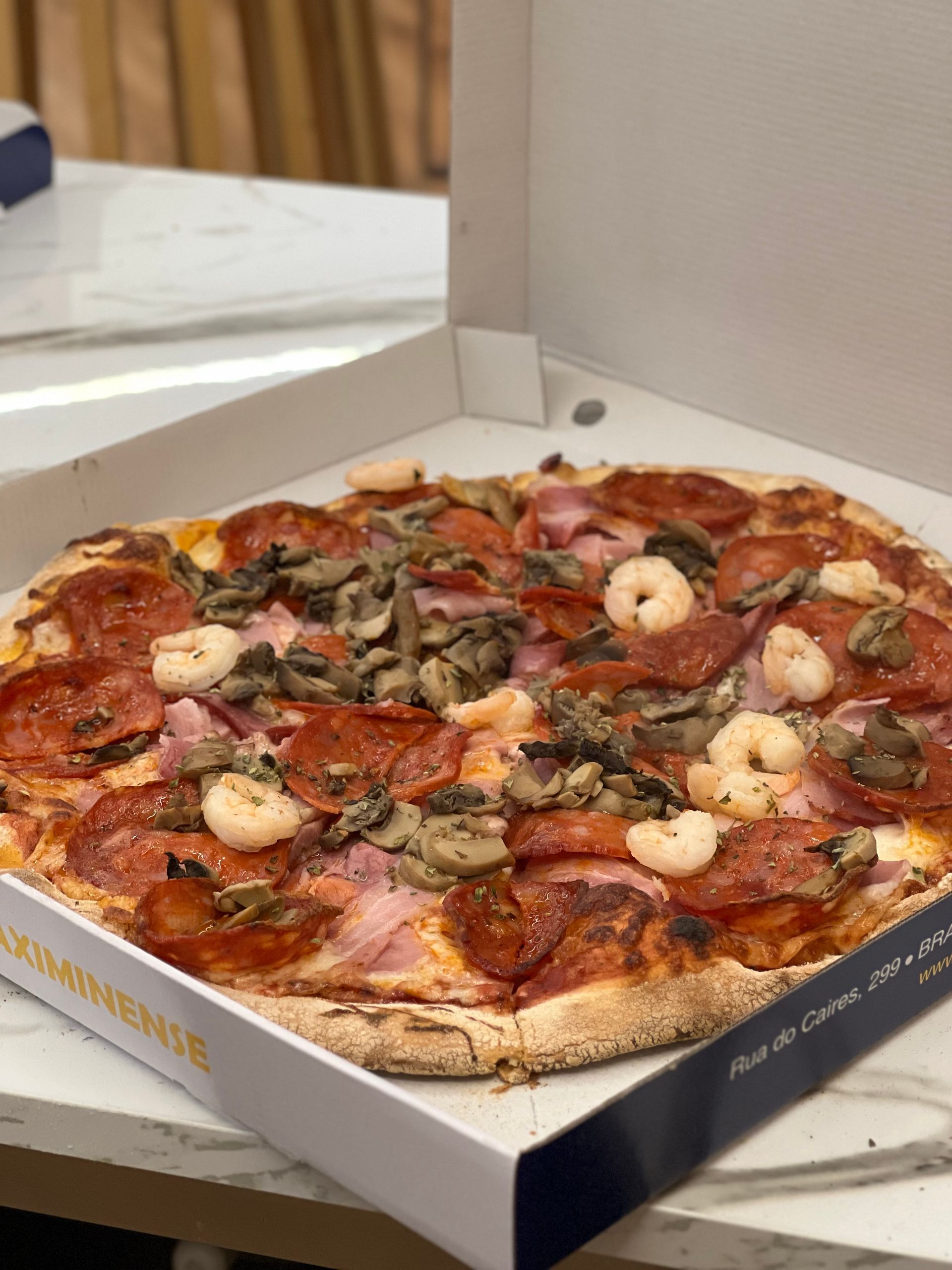 Uma pessoa está tirando uma fatia de pizza de uma caixa.