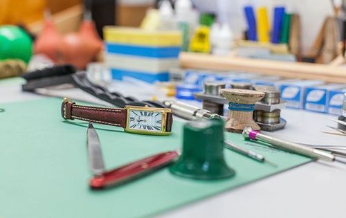 Eine Uhr liegt auf einer grünen Matte auf einem Tisch.