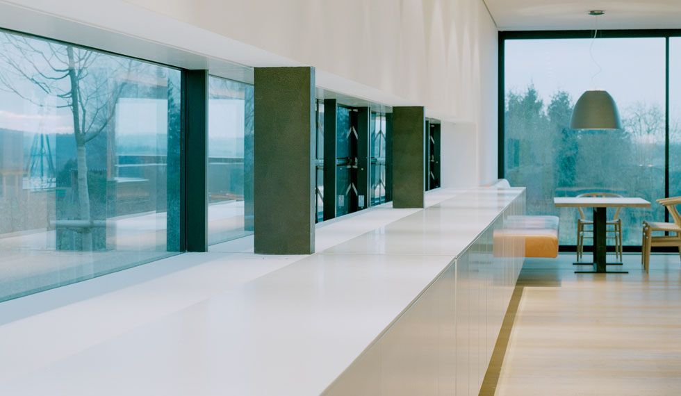 Ein Raum mit einem Tisch und Stühlen vor einem großen Fenster.