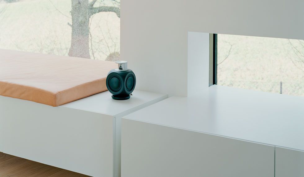 Auf einem Tisch neben einem Fenster steht eine Flasche Seife.