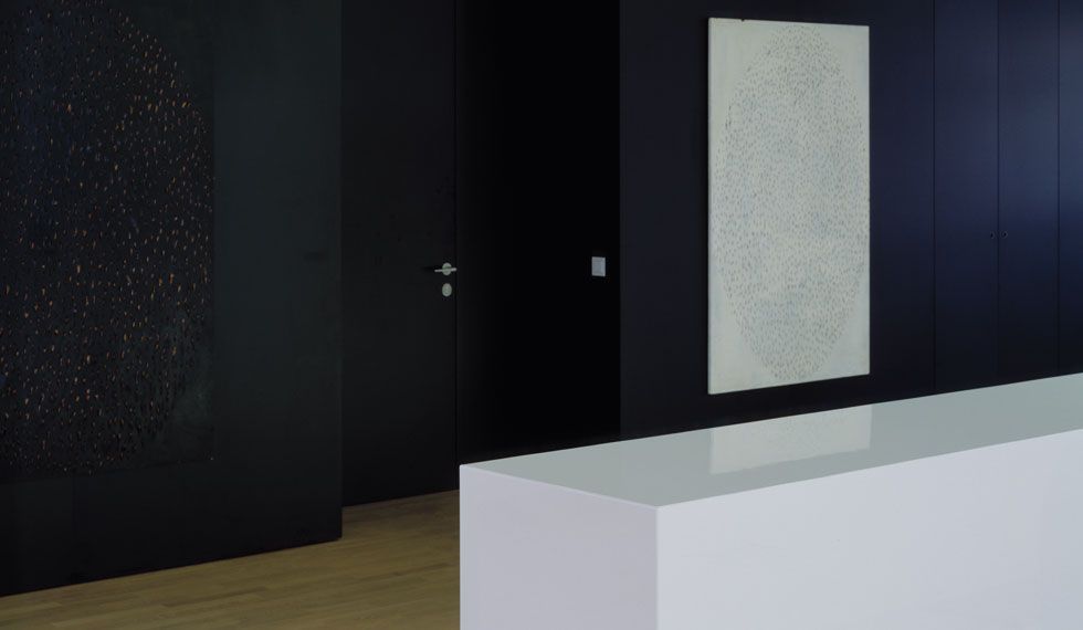 Eine weiße Theke in einem Raum mit einem Gemälde an der Wand.