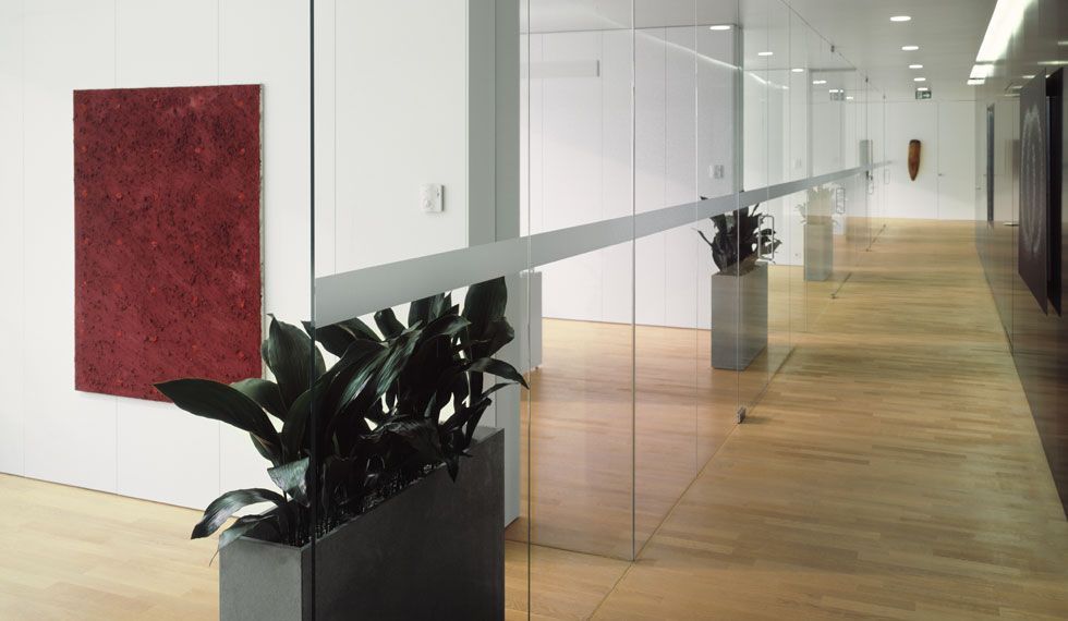 Ein Flur mit Pflanzen in Pflanzkübeln und einem Gemälde an der Wand