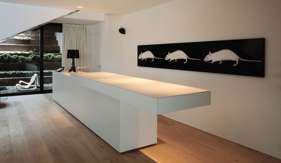 Eine lange weiße Theke in einem Raum mit einem Bild von Mäusen an der Wand.