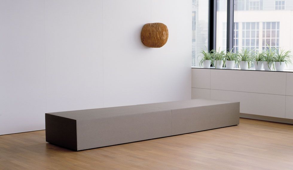 Ein Raum mit einer Bank und einer Skulptur an der Wand