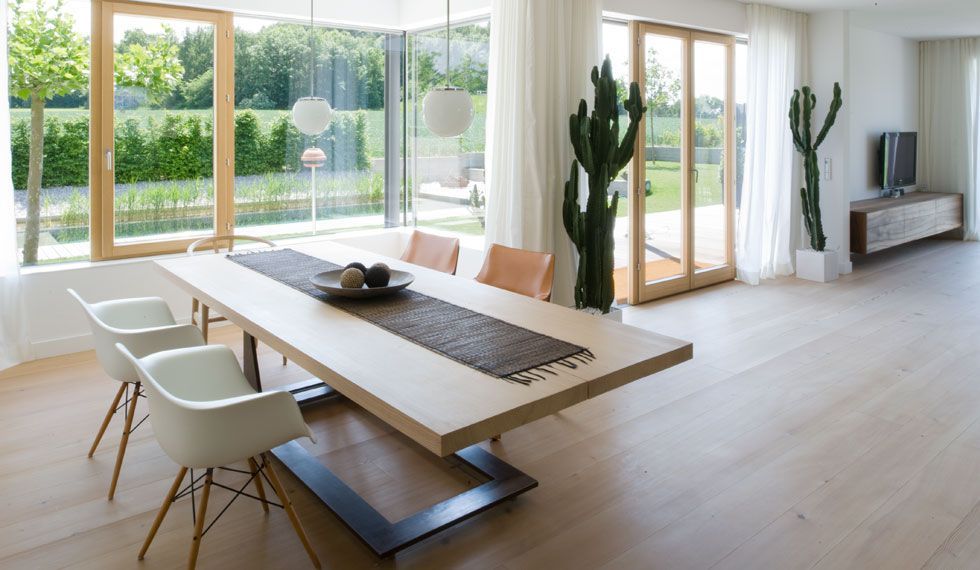 Ein Esszimmer mit einem Holztisch und Stühlen und einem großen Fenster.