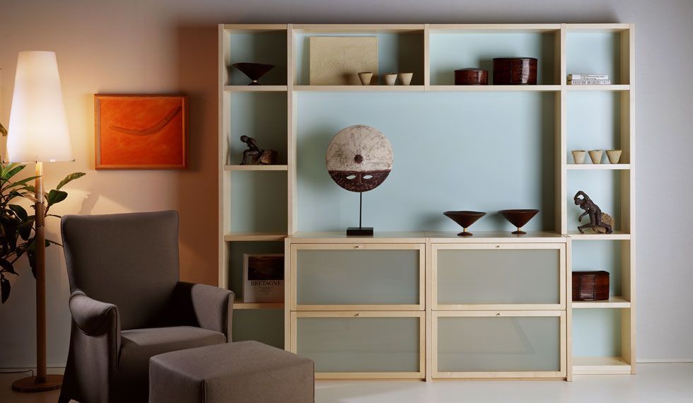 Ein Wohnzimmer mit einem großen Regal und einem Stuhl