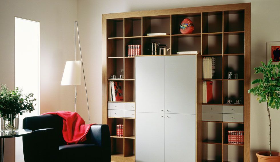 Ein Wohnzimmer mit vielen Regalen und einem Stuhl