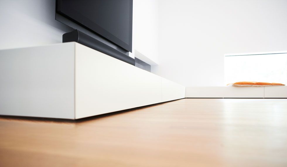 In einem Wohnzimmer steht ein Fernseher auf einem weißen Entertainment-Center.