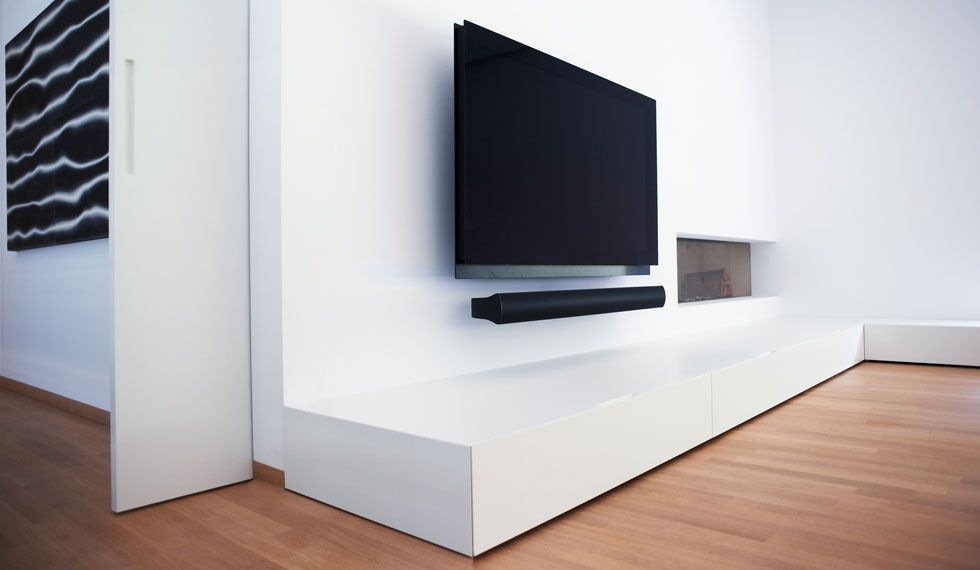 Ein Wohnzimmer mit einem an der Wand montierten Flachbildfernseher