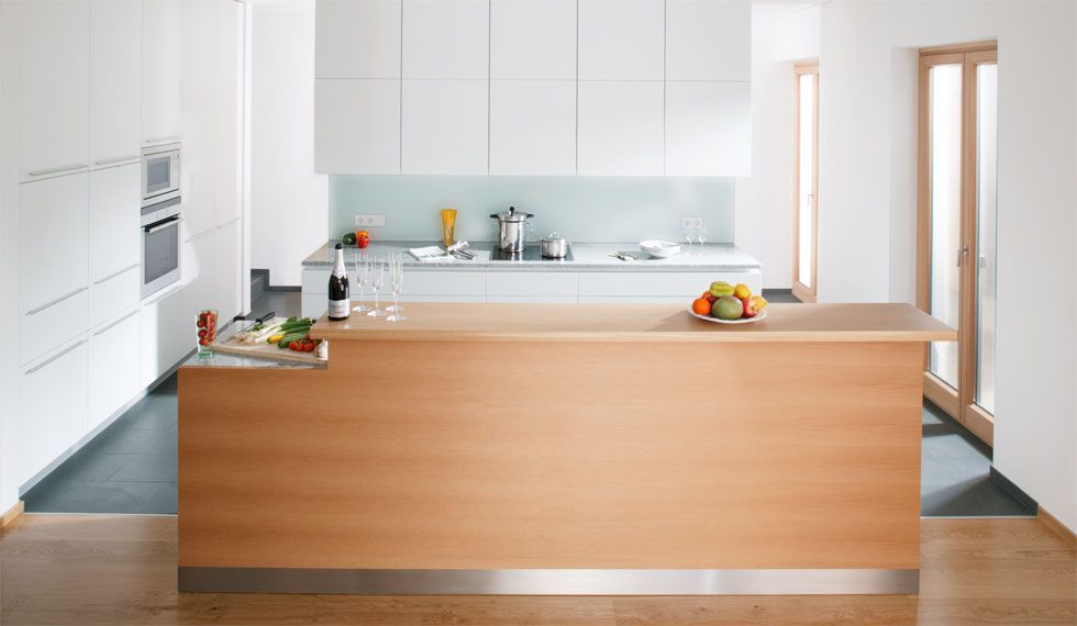 Eine Küche mit weißen Schränken und einer Holzinsel