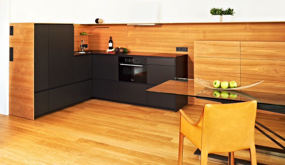 Eine Küche mit Tisch und Stühlen und einer Flasche Wein auf der Theke.