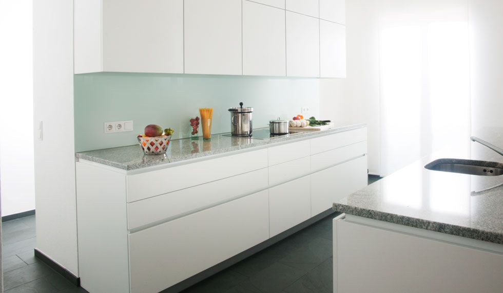 Eine Küche mit weißen Schränken, Granitarbeitsplatten und einer Spüle.