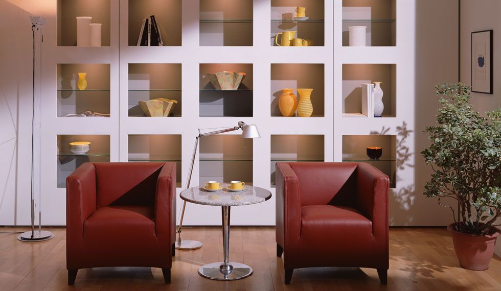 Ein Wohnzimmer mit zwei roten Stühlen und einem Tisch