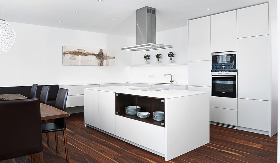 Eine Küche mit weißen Schränken und einer großen Insel in der Mitte