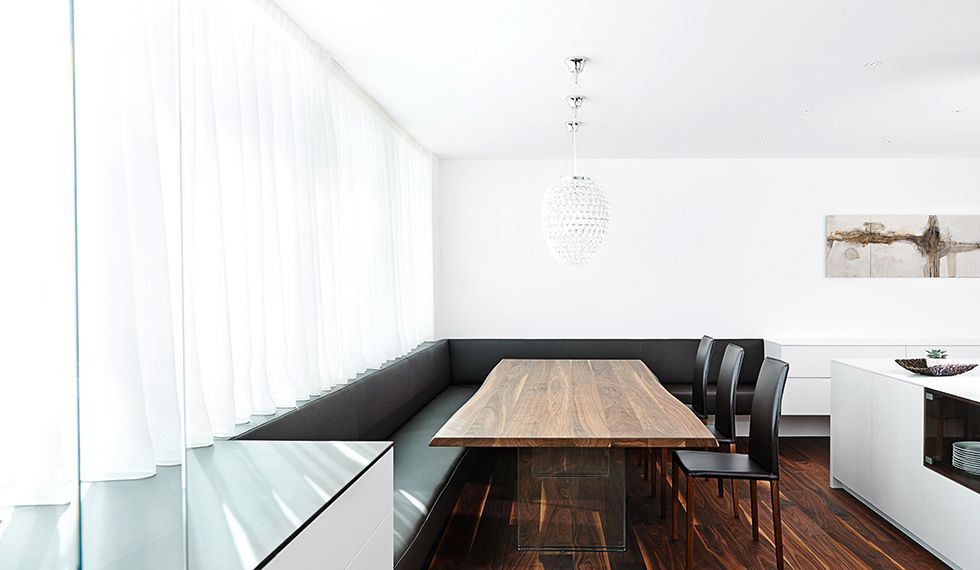 Ein Esszimmer mit einem langen Holztisch und Stühlen