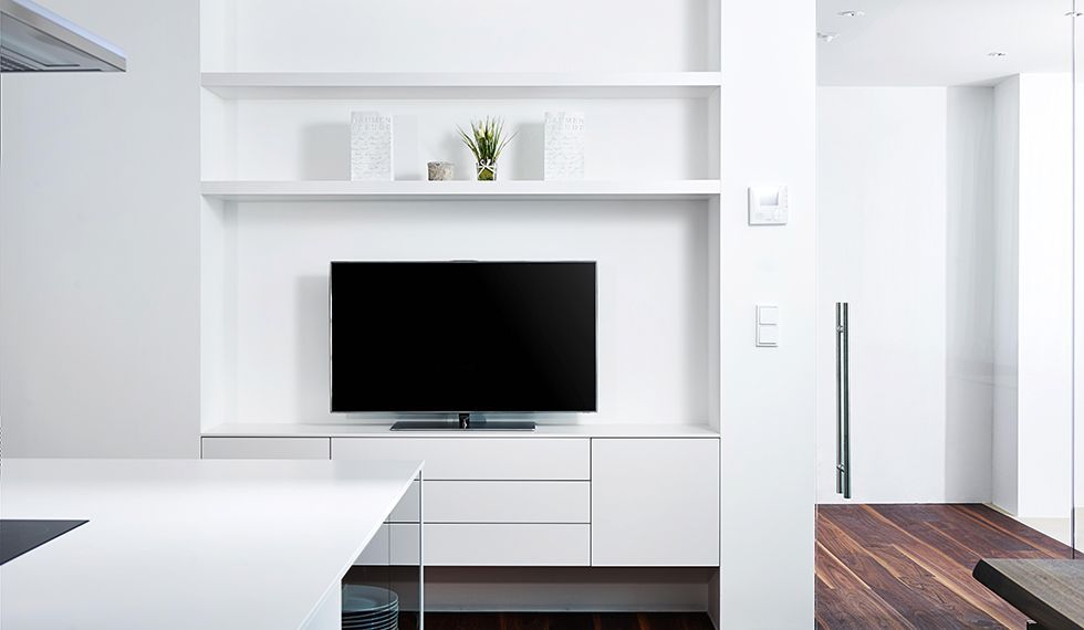 Ein Flachbildfernseher ist an der Wand in einem Wohnzimmer montiert.