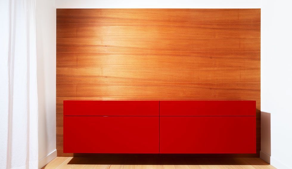 Ein roter Schrank vor einer Holzwand