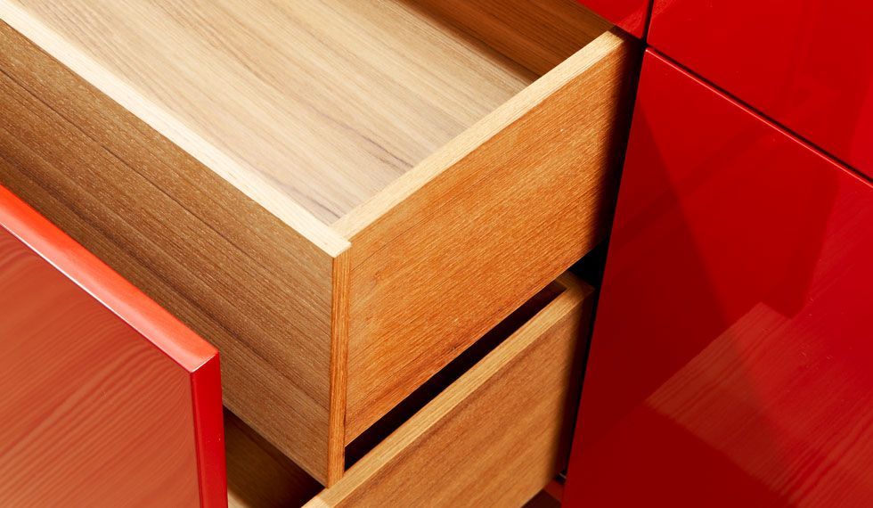 Eine Nahaufnahme einer Holzschublade in einem roten Schrank.