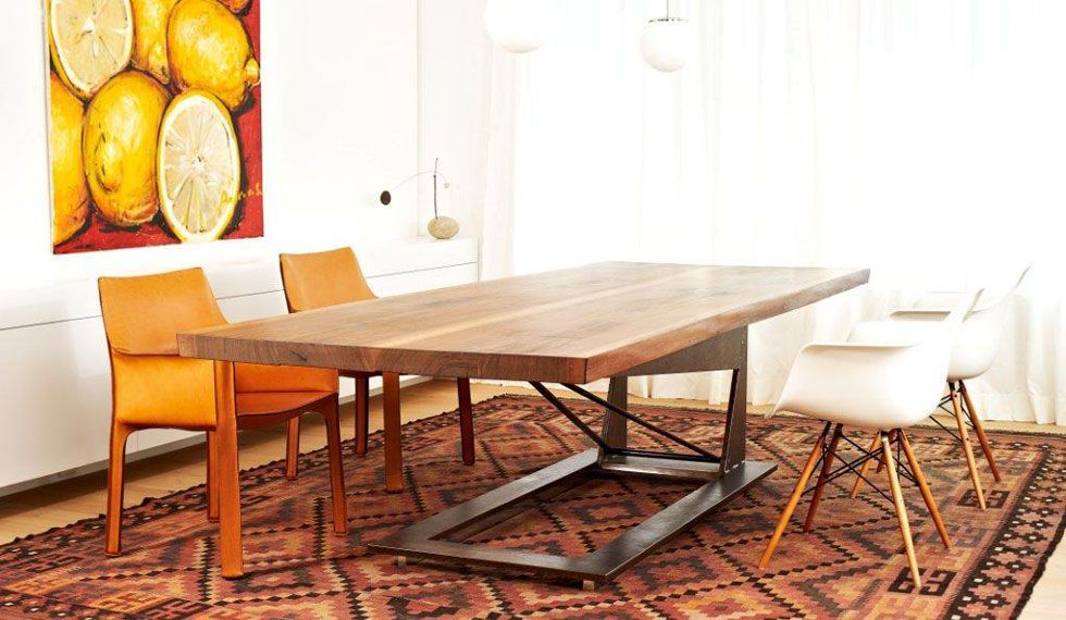 Ein Esszimmer mit einem Holztisch und Stühlen und einem Teppich.