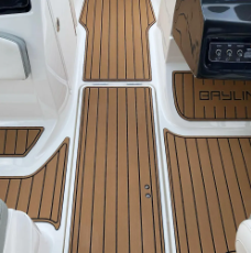 Weisses Bootsdeck mit hellbraunem Teakholzboden und einer kleinen Holzkonsole mit der Aufschrift „Graylin“