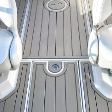 Graues Bootsdeck mit weissen Sitzen und zwei runden Bodenabläufen