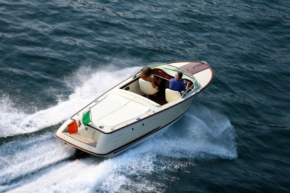 Ein kleines weisses Schnellboot pflügt durch das aufgewühlte blaue Wasser und hinterlässt eine schäumende Kielwasser.