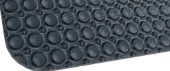 Schwarze Gummimatte mit erhabenen kreisförmigen Noppen, hier in Nahaufnahme aus einem bestimmten Winkel gezeigt.