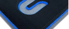 Nahaufnahme eines schwarzen Mauspads mit blau leuchtendem Logo und blauer Randeinfassung