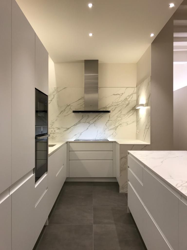 Una cocina con gabinetes blancos y un horno de estufa.