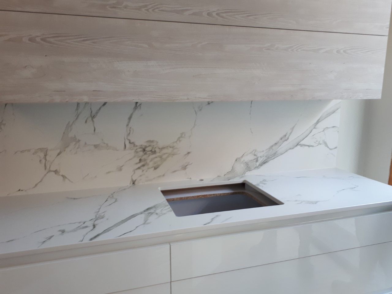 Una cocina con fregadero y encimera de mármol.