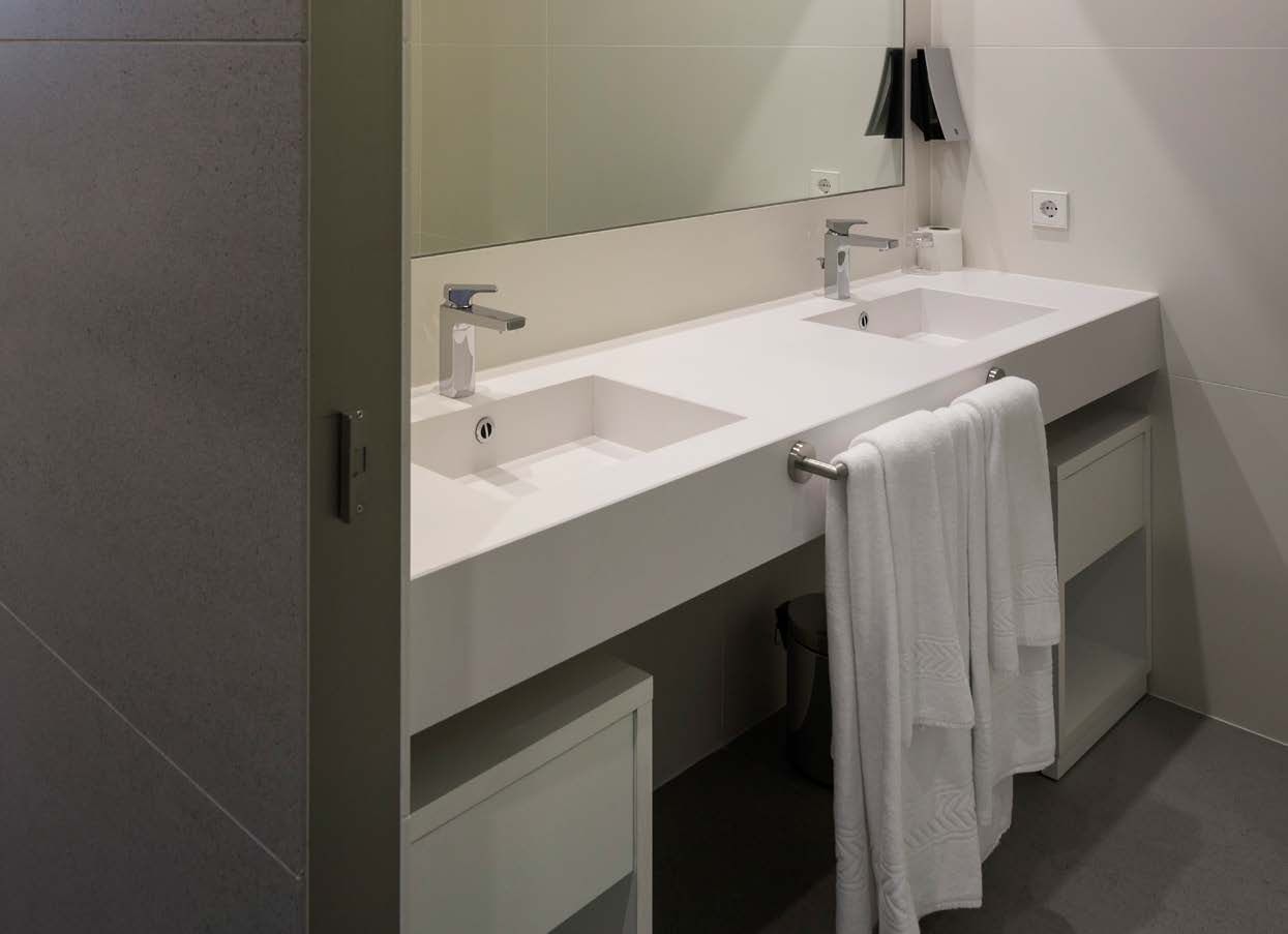 Un baño con dos lavabos y un espejo.