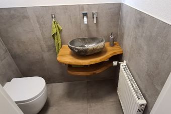 Badezimmer mit Boden aus großen Fliesen