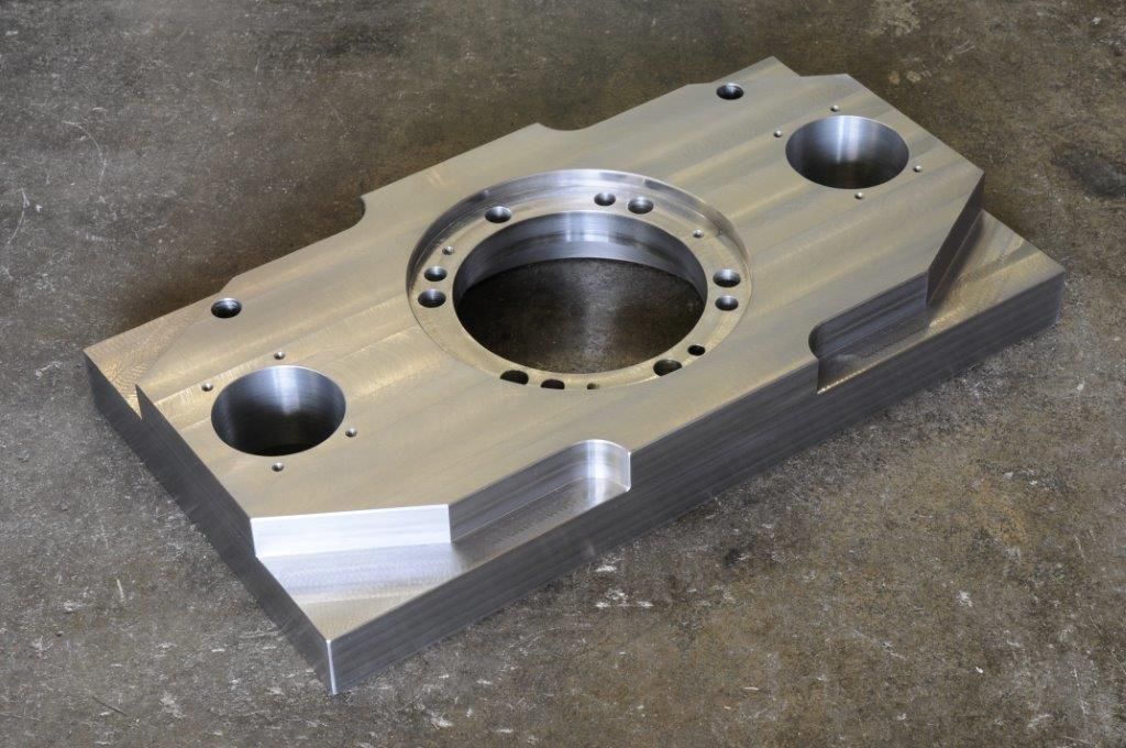 ein Metallstück mit einem Loch in der Mitte liegt auf einem Betonboden .