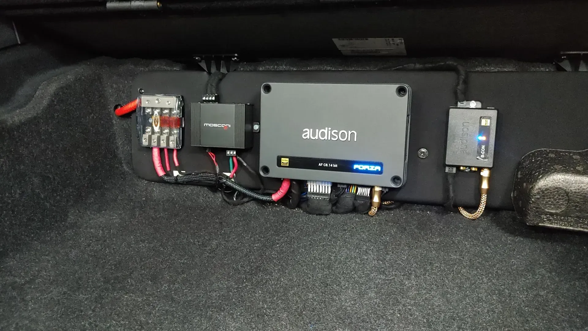 Equipo de audio del automóvil: amplificador, bloque de fusibles y unidad de control, montados en el interior de un vehículo.