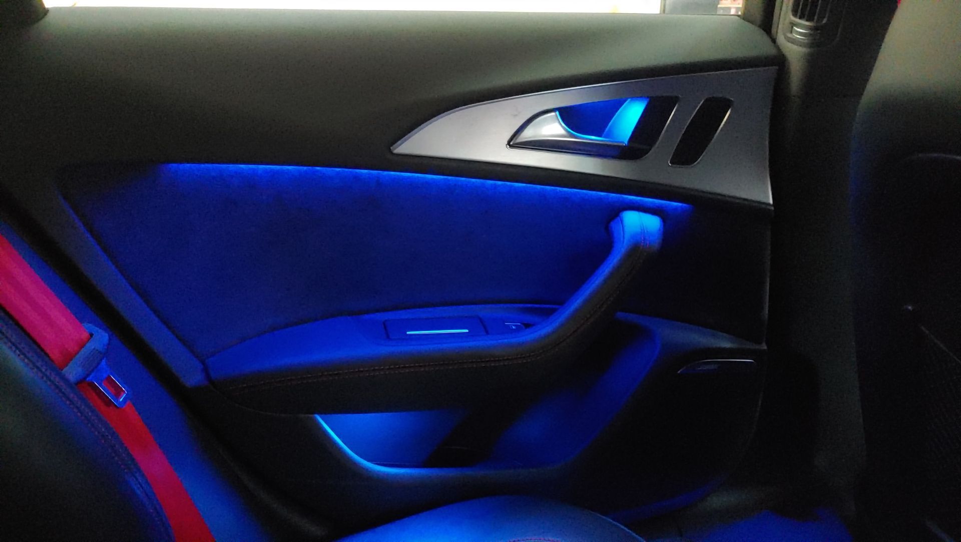 Puerta interior del coche con iluminación ambiental azul.seguridad rojo visible.