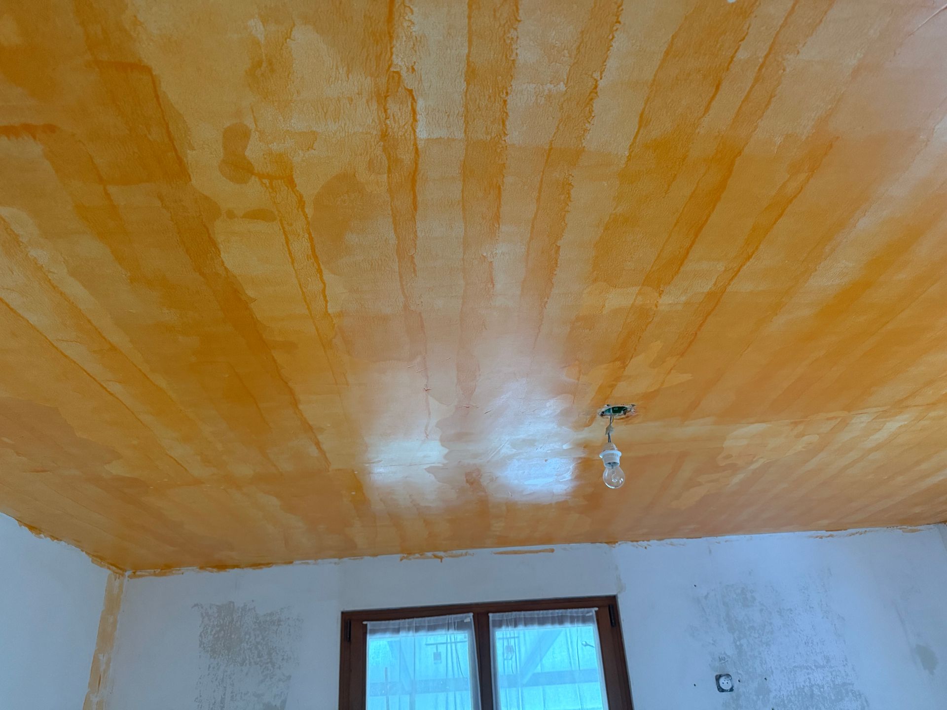 Un faux plafond et une porte-fenêtre.