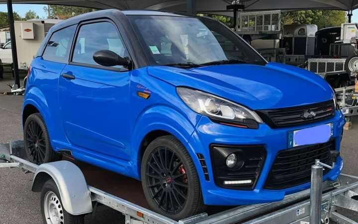 Une voiture bleue sur une remorque.