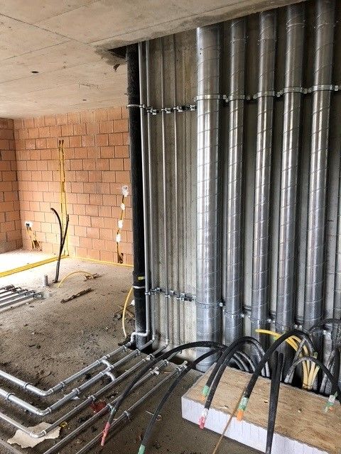 Baustelle: Rohre und Leitungen verlaufen an Wänden und Decken entlang.
