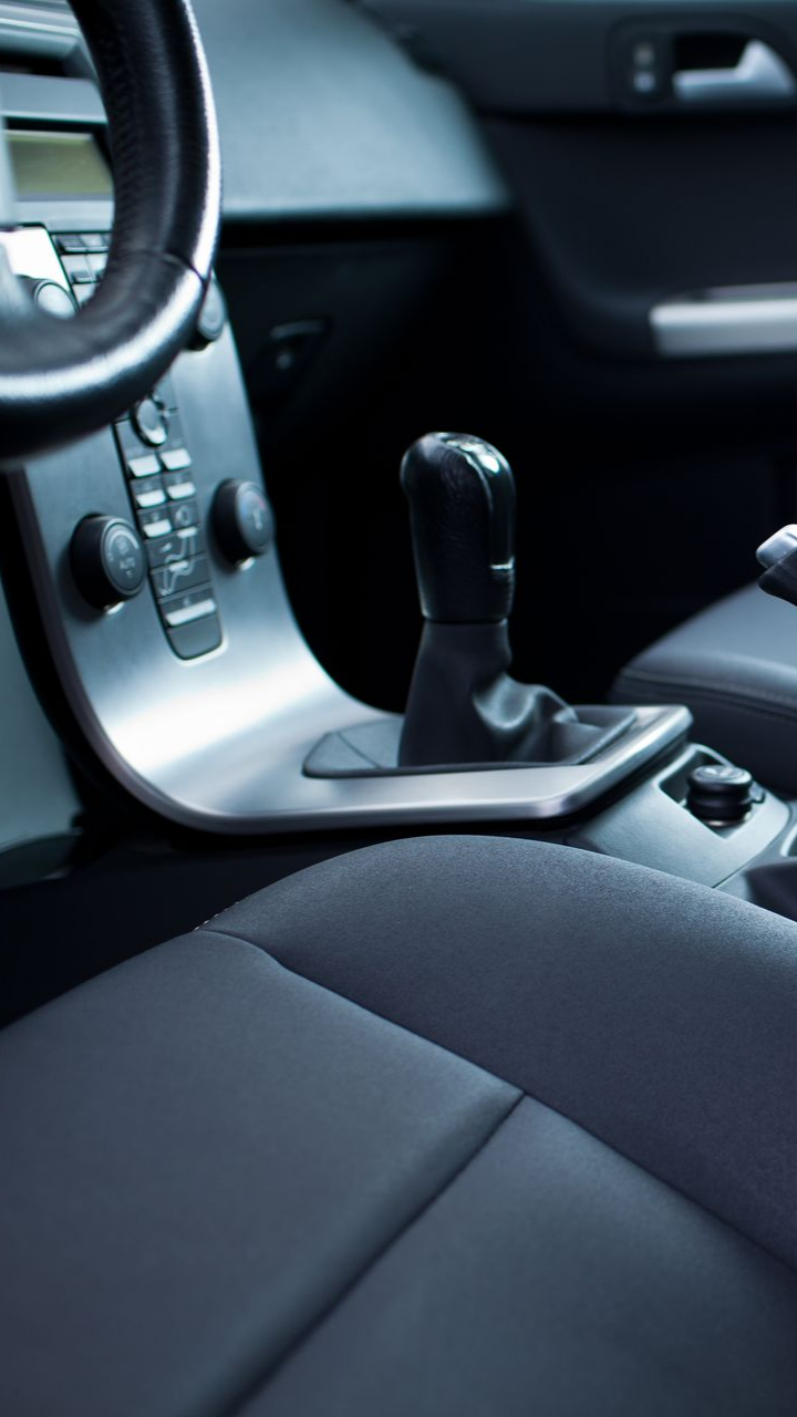 Intérieur d'une voiture à boîte de vitesses manuelle. Sellerie et tableau de bord noirs avec volant.